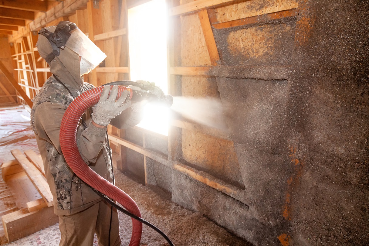 Insulation tool held by brazos thermal worker spraying cellulose insulation in new residential home.