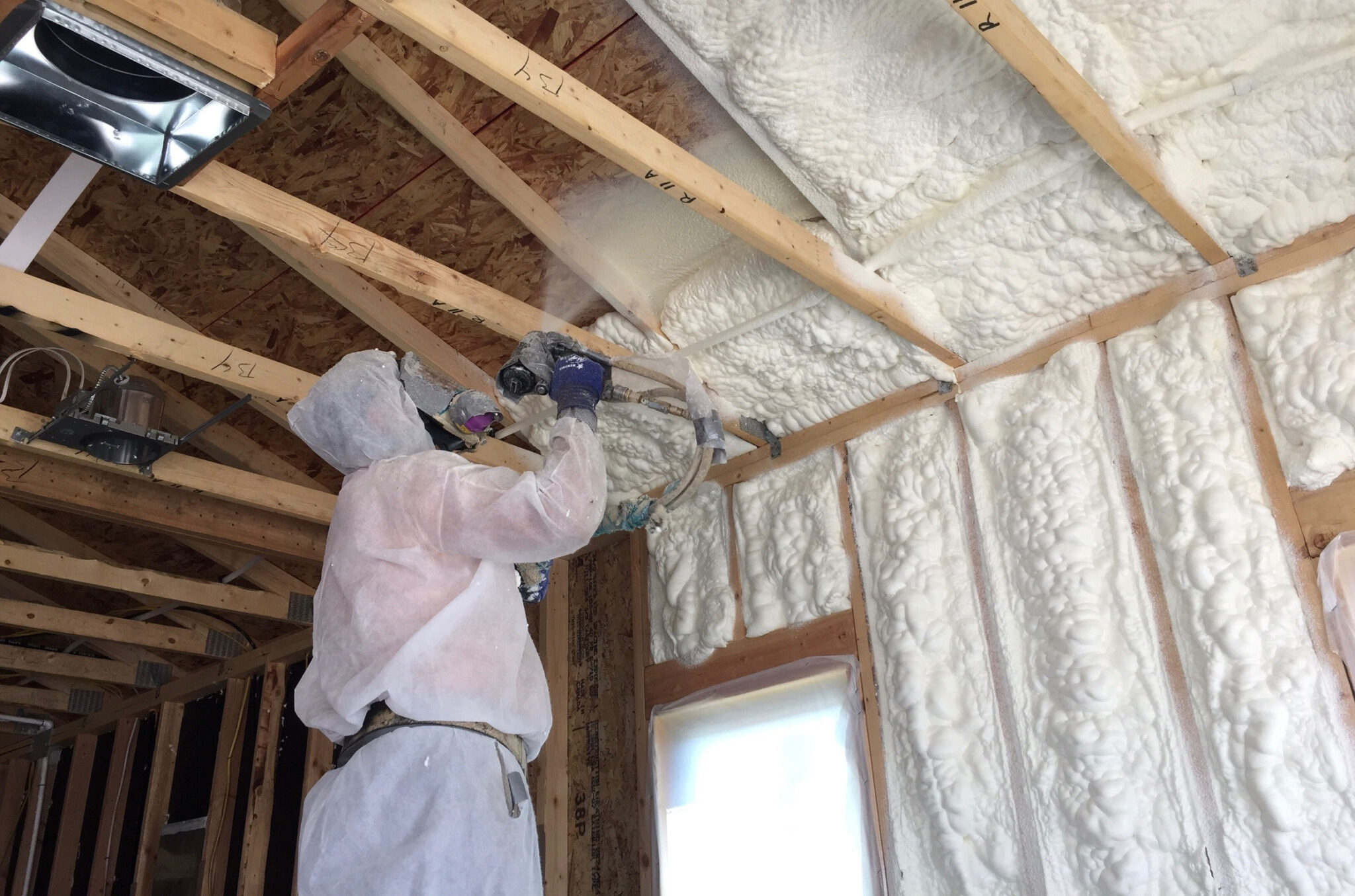 Brazos worker spraying foam insulation for a new residential home.