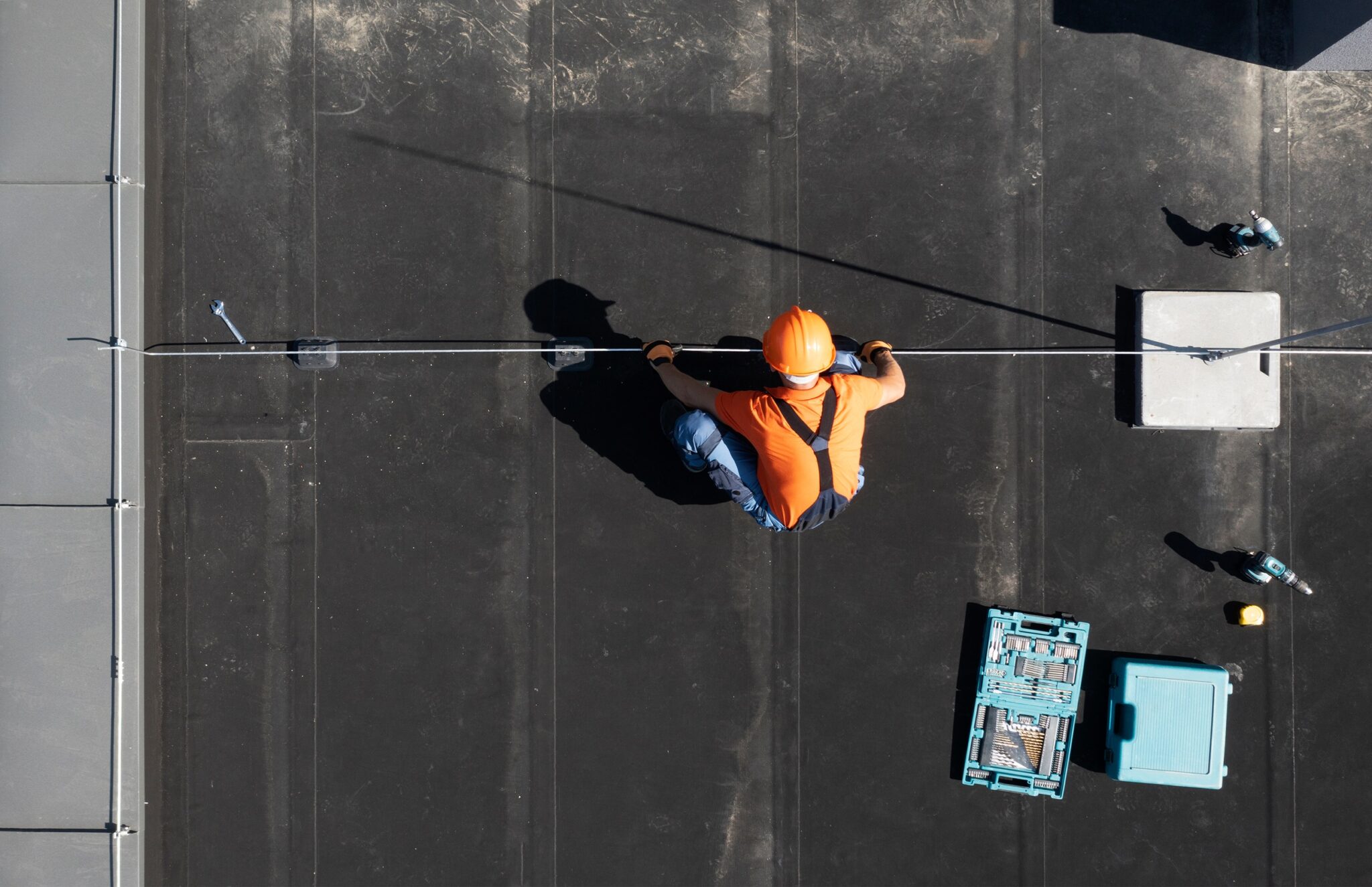 Overhead view of a worker working on installation on a roof.