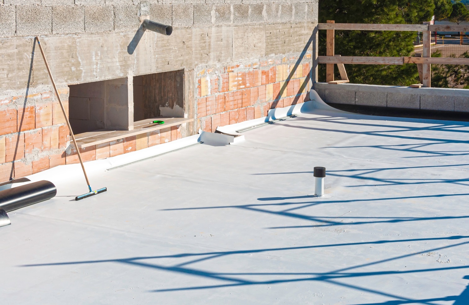 Roof under construction with exposed brick and pipping as well.