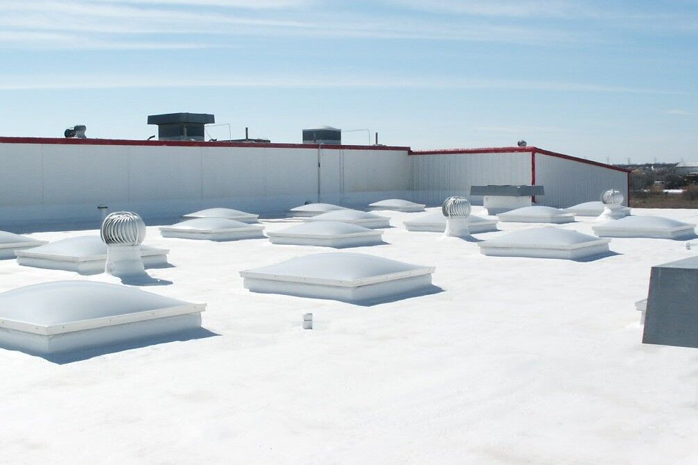 Commercial roof with multiple skylights and vent hoods that have just been refinished by brazos thermal.