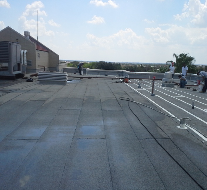 Brazos Thermal workers on commercial roof installing modified bitumen.