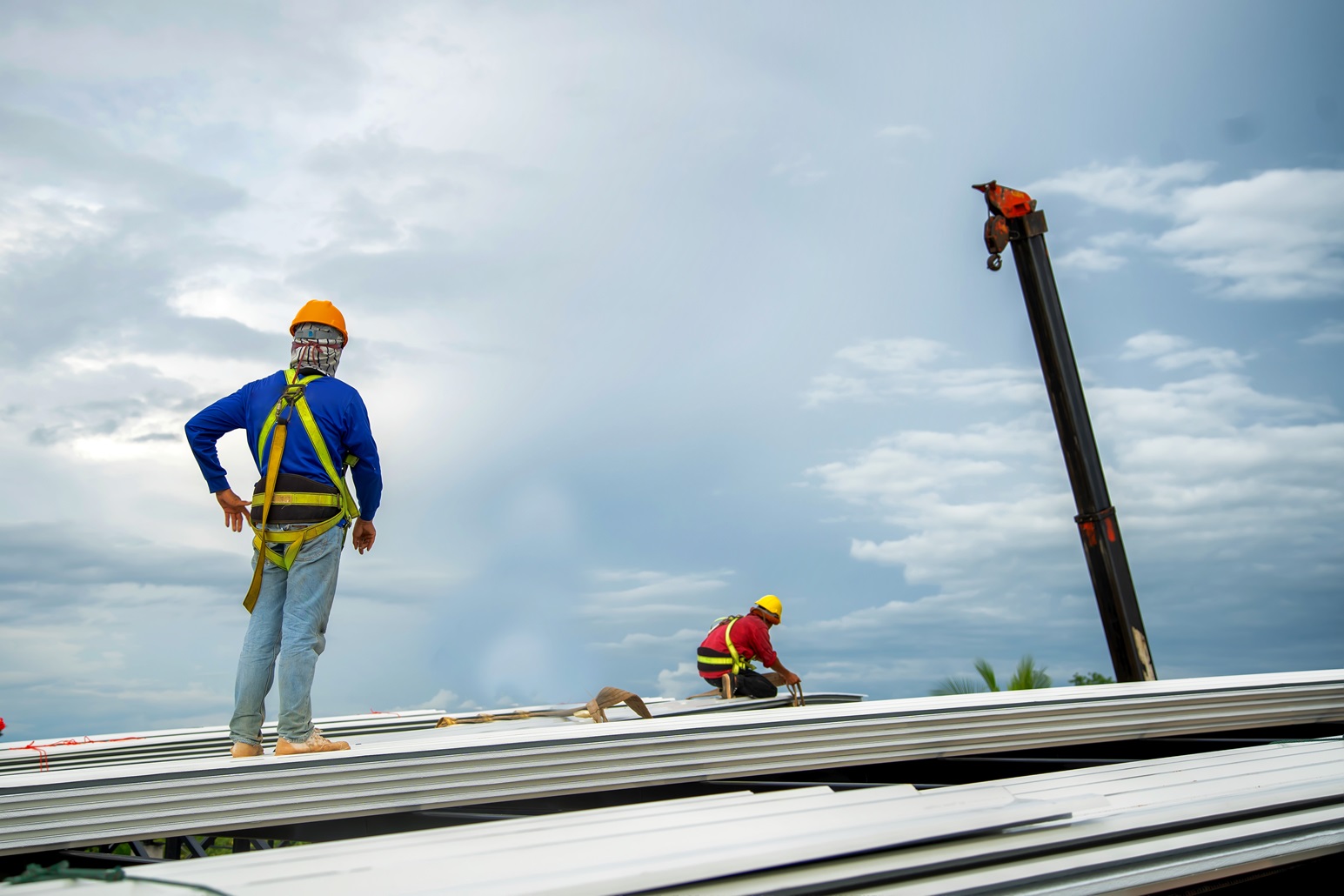 Brazos Thermal workers restoring a roof with sky in the background.