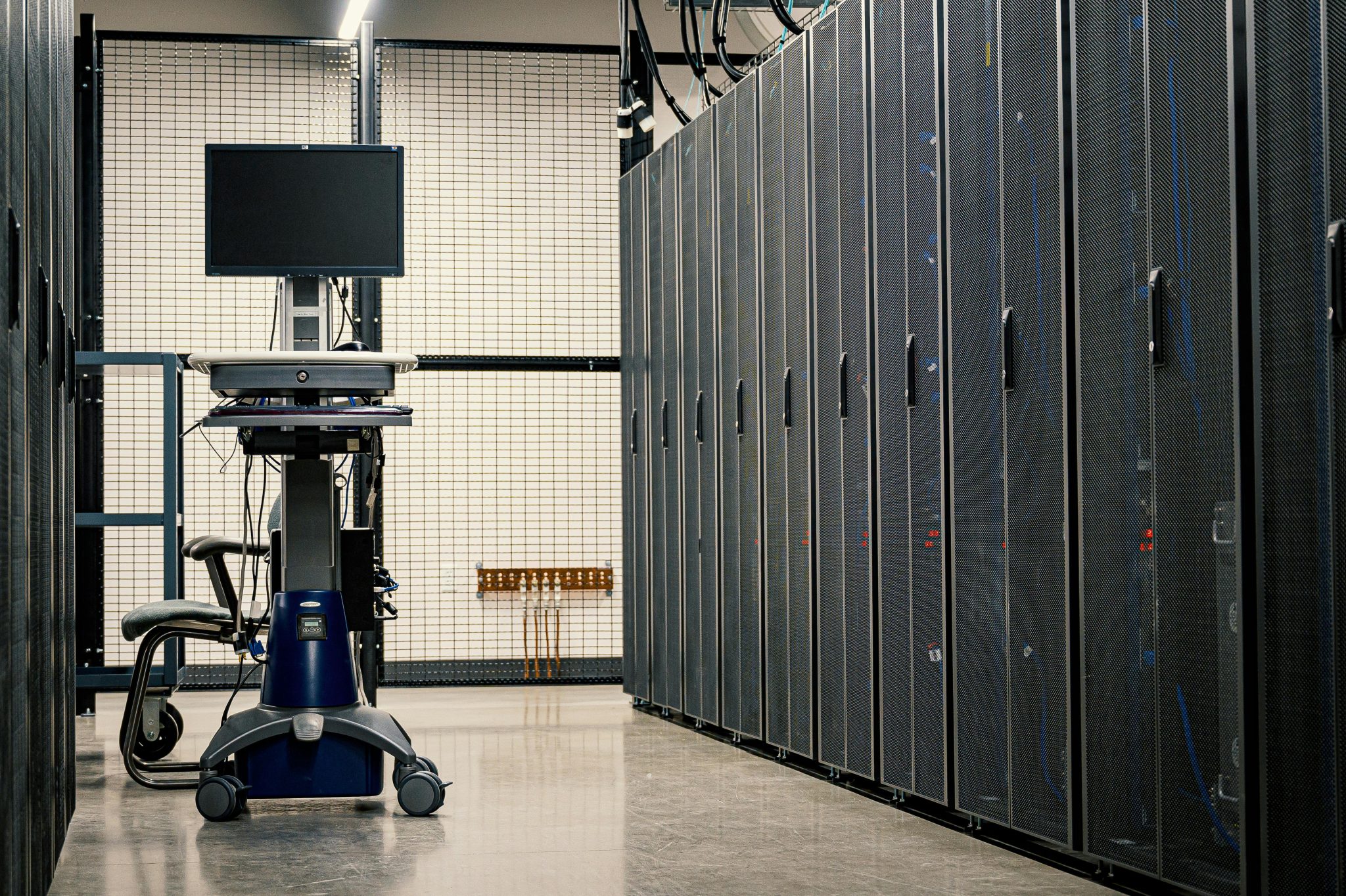 A computer cart parked between rows of servers in a data center.