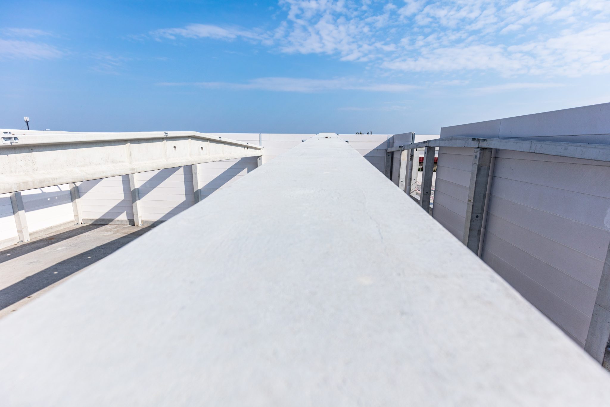 An industrial roof with a white roof coating on it on a sunny day.