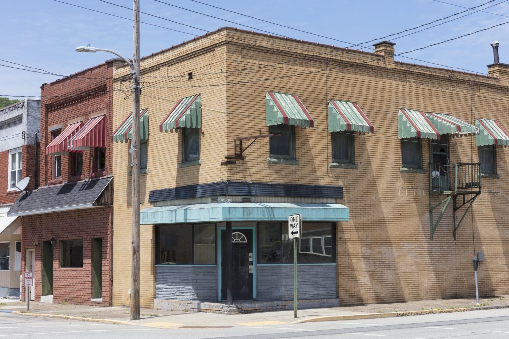 Old commercial buildings stand along a street corner.
