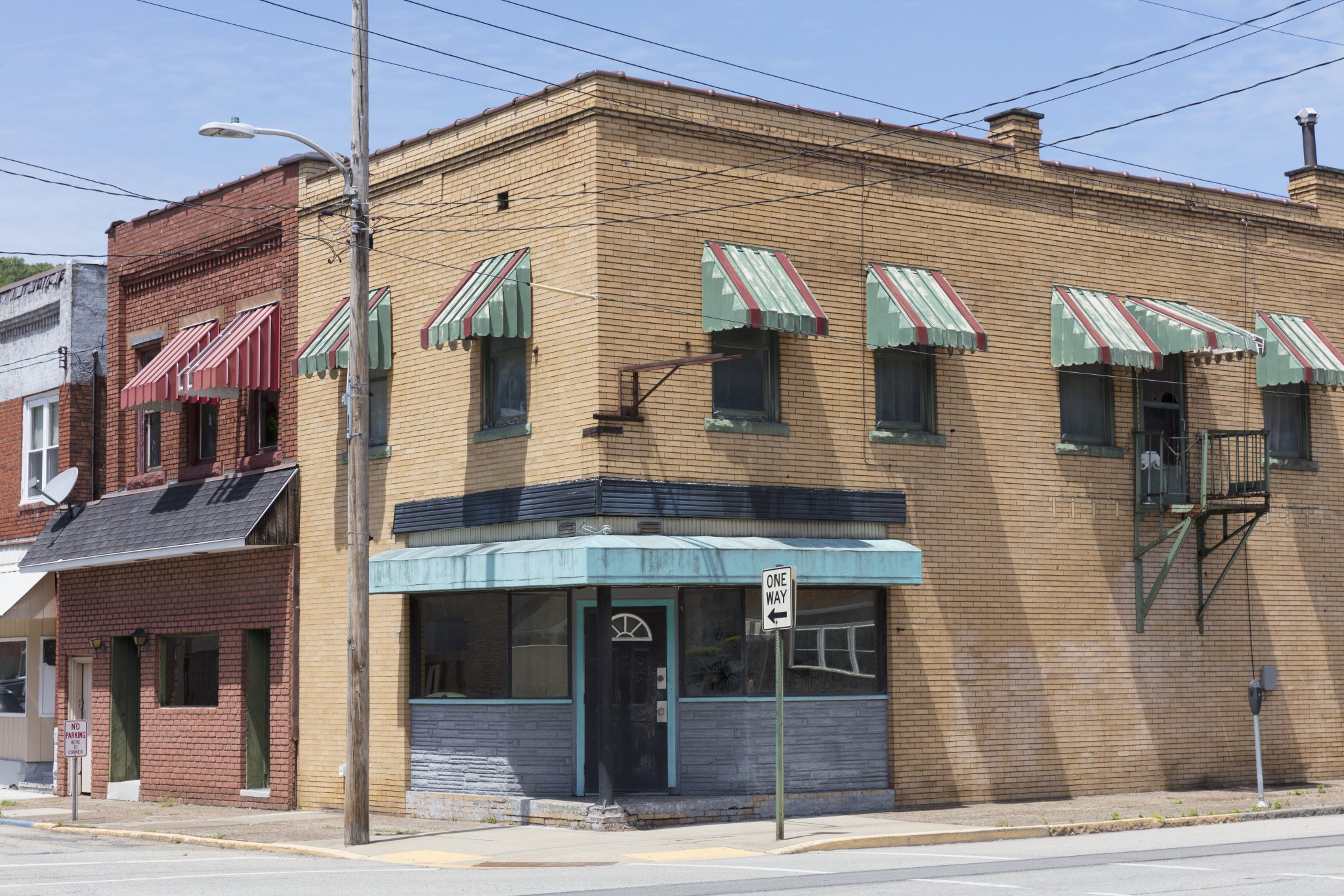 Old commercial buildings stand along a street corner.