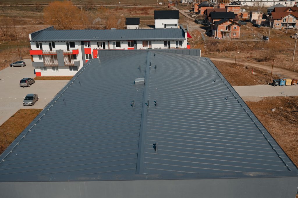 Two white commercial buildings with gray metal roofs.